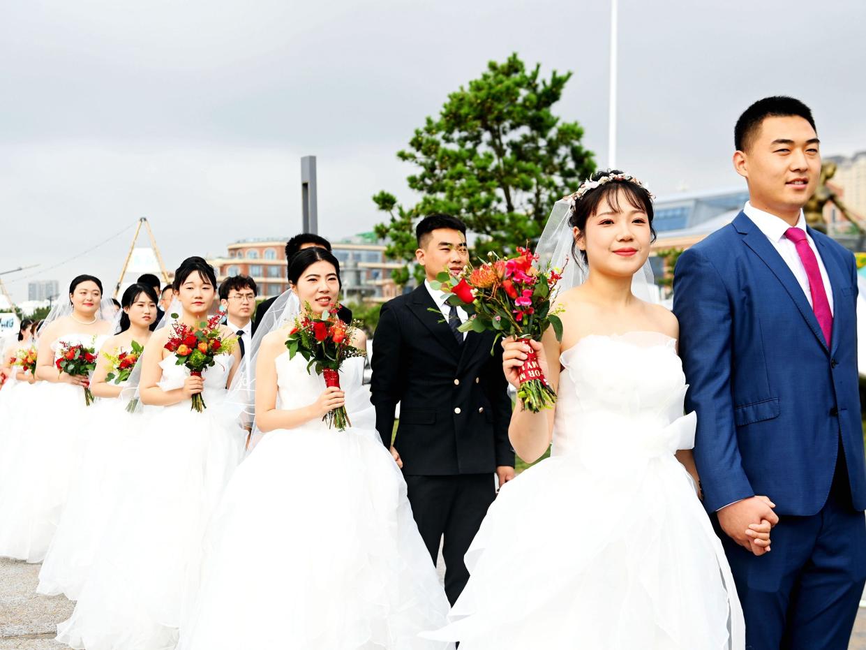 Couples attend a collective wedding at Love Bay, Golden Beach Beer City in Qingdao, Shandong province, China, August 22, 2023.