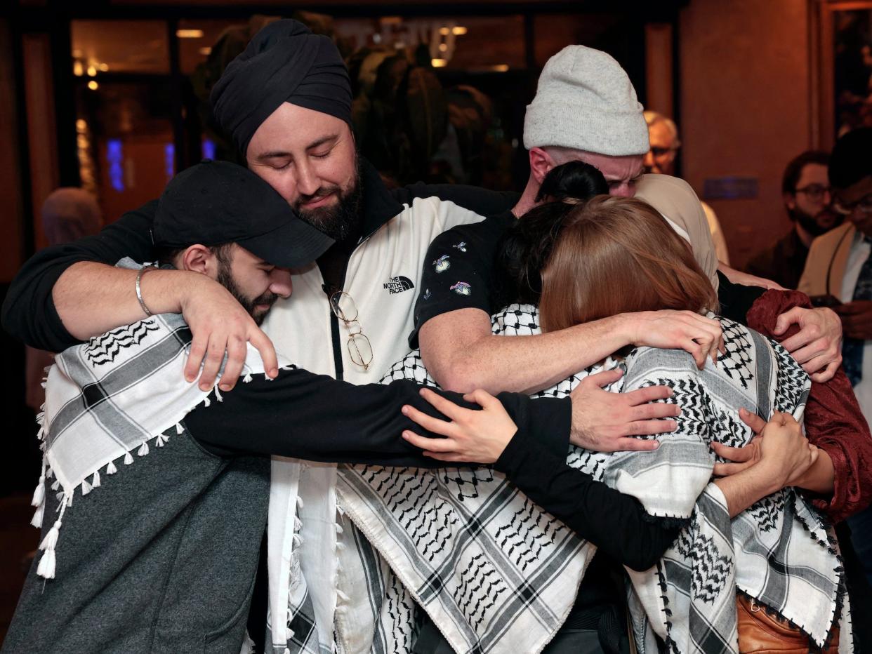 Supporters of the "Listen to Michigan" campaign embrace at a February watch party.