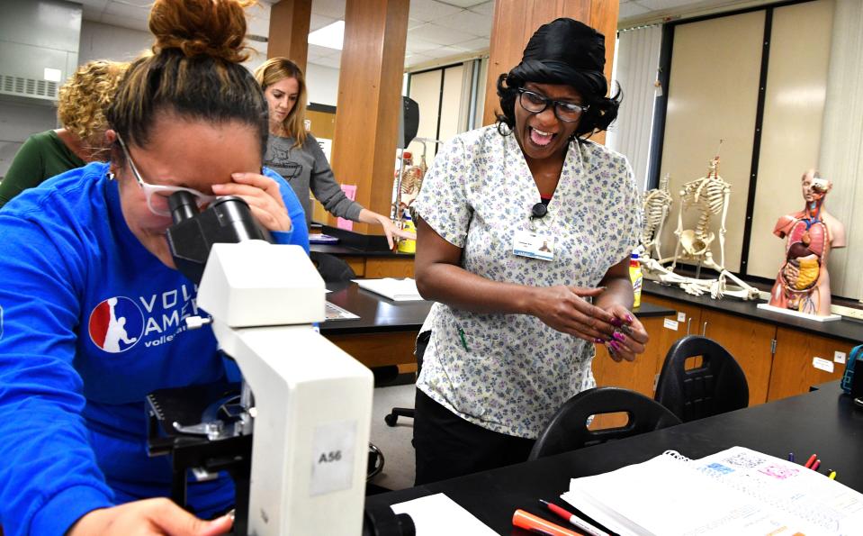 Sheeteah Blair looks on with fellow student as they examine tissue samples during a 2018 anatomy class at Nashville State. Blair used the free Tennessee Reconnect program to pursue a nursing degree.