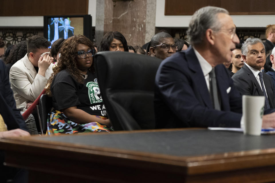 Sam Amato, left, of Buffalo, N.Y., who is a member of the Union and says he was illegally fired from Starbucks after 13 years, becomes emotional during testimony by former Starbucks CEO Howard Schultz, at right, before the Senate Health, Education, Labor and Pensions committee, Wednesday, March 29, 2023, on Capitol Hill in Washington. (AP Photo/Jacquelyn Martin)