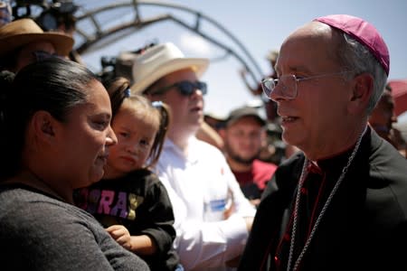 El Paso Bishop Mark Seitz chats with Honduran migrants who were deported after crossing the Paso del Norte international border from El Paso, Texas, U.S., in Ciudad Juarez, Mexico