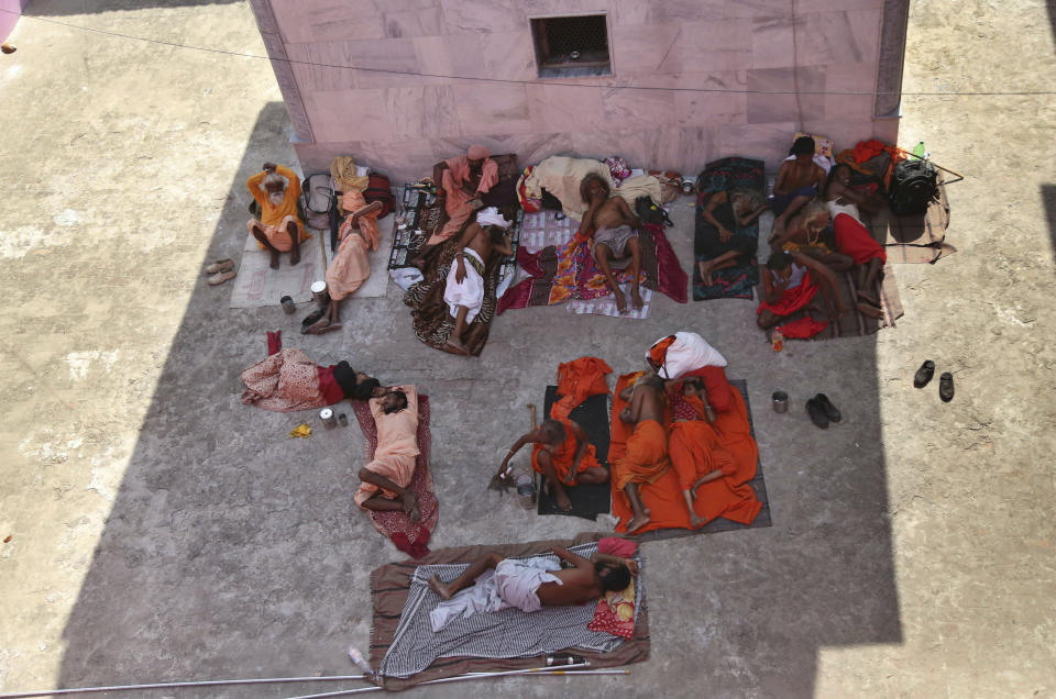 Hindu holy men take rest at a base camp for the annual pilgrimage to the Amarnath cave shrine in Jammu, India, Monday, July 1, 2019. Thousands of Hindu pilgrims began the arduous trek to an icy Himalayan cave in disputed Kashmir on Monday, with tens of thousands of Indian government forces guarding roads and mountain passes. (AP Photo/Channi Anand)