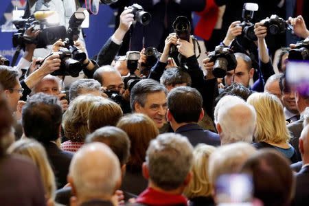 Francois Fillon (C), former French prime minister and member of Les Republicains political party, attends a rally as he campaigns in the second round for the French center-right presidential primary election in Paris, France, November 25, 2016. REUTERS/Philippe Wojazer