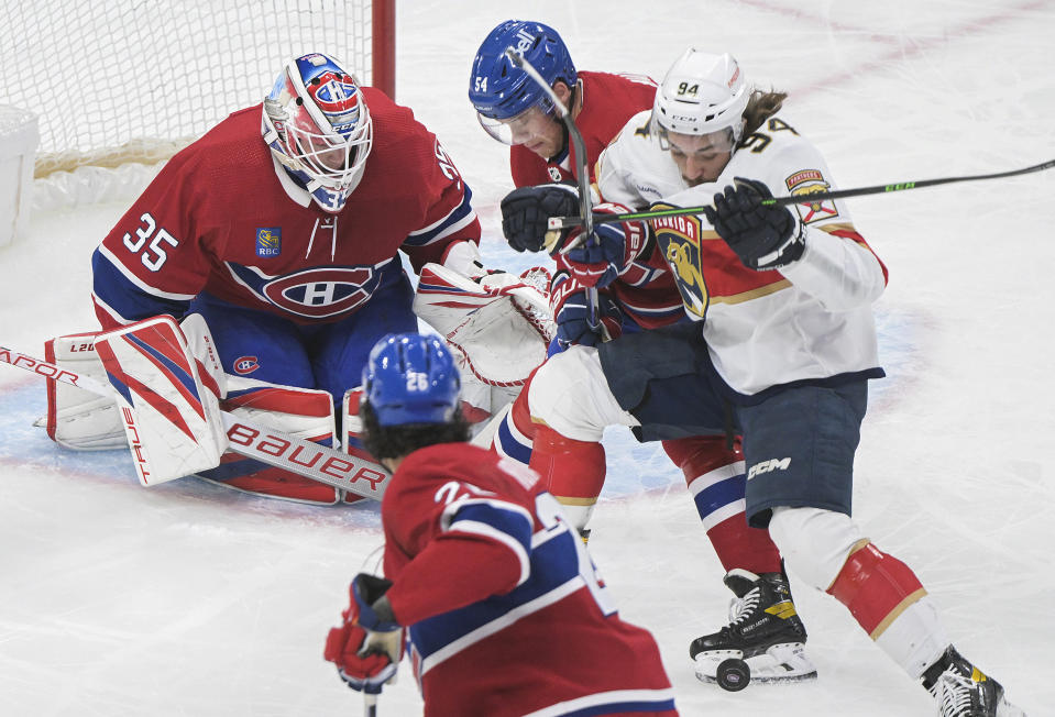 Florida Panthers' Ryan Lomberg (94) is defended by Montreal Canadiens' Jordan Harris (54) and Johnathan Kovacevic (26) in front of goaltender Sam Montembeault during the second period of an NHL hockey game Thursday, March 30, 2023, in Montreal. (Graham Hughes/The Canadian Press via AP)