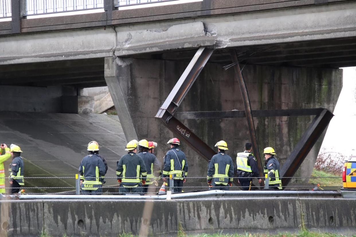 Firefighters attend the collision scene on Dec. 28 when an owner-operator for Chohan Freight Forwarders crashed into a highway overpass in Delta, B.C. (Shane MacKichan - image credit)