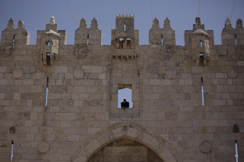 Israeli policeman uses the Damascus Gate to watch Muslim worshippers leave the Old City of Jerusalem after Friday prayers during the Muslim holy month of Ramadan, on Friday, April 23, 2021 in Jerusalem. Israeli police say 44 people were arrested and 20 officers were wounded in a night of chaos in Jerusalem, where security forces separately clashed with Palestinians angry about Ramadan restrictions and Jewish extremists who held an anti-Arab march nearby. (AP Photo/Maya Alleruzzo)