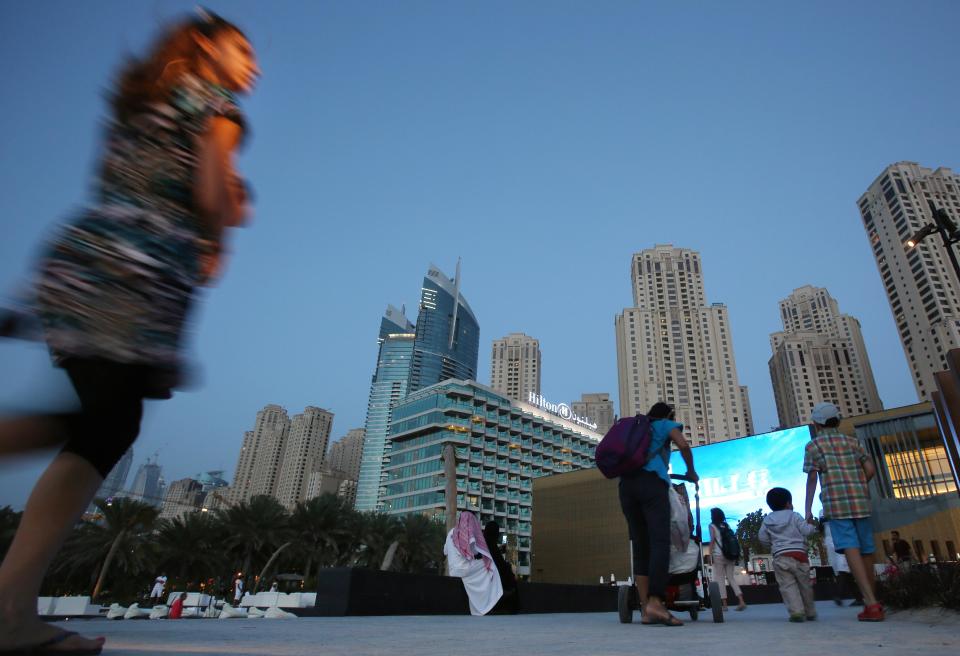 In this Monday, April 21, 2014 photo, people prepare to watch a movie at an outdoor cinema at the beach in Dubai, United Arab Emirates. Most of the luxury towers along the beach have been built only in the past decade. Some are homes to foreign professionals working in the Gulf commercial hub, others vacation properties or a place to park some cash for wealthy businesspeople from Russia, Asia and nearby Saudi Arabia. (AP Photo/Kamran Jebreili)