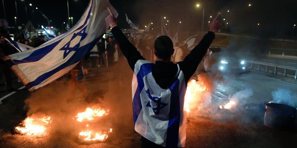 Anti-government protestors burn tires near Beit Yanai, Israel, Monday, March 27, 2023.