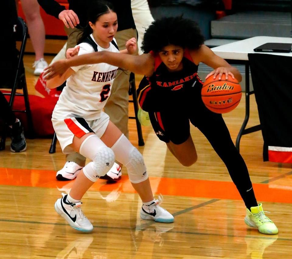 Kamiakin’s Nikole Thomas drives her way around Kennewick defender Hannah Fiander (2) during their Jan. 18, 2022 game at Kennewick High School.