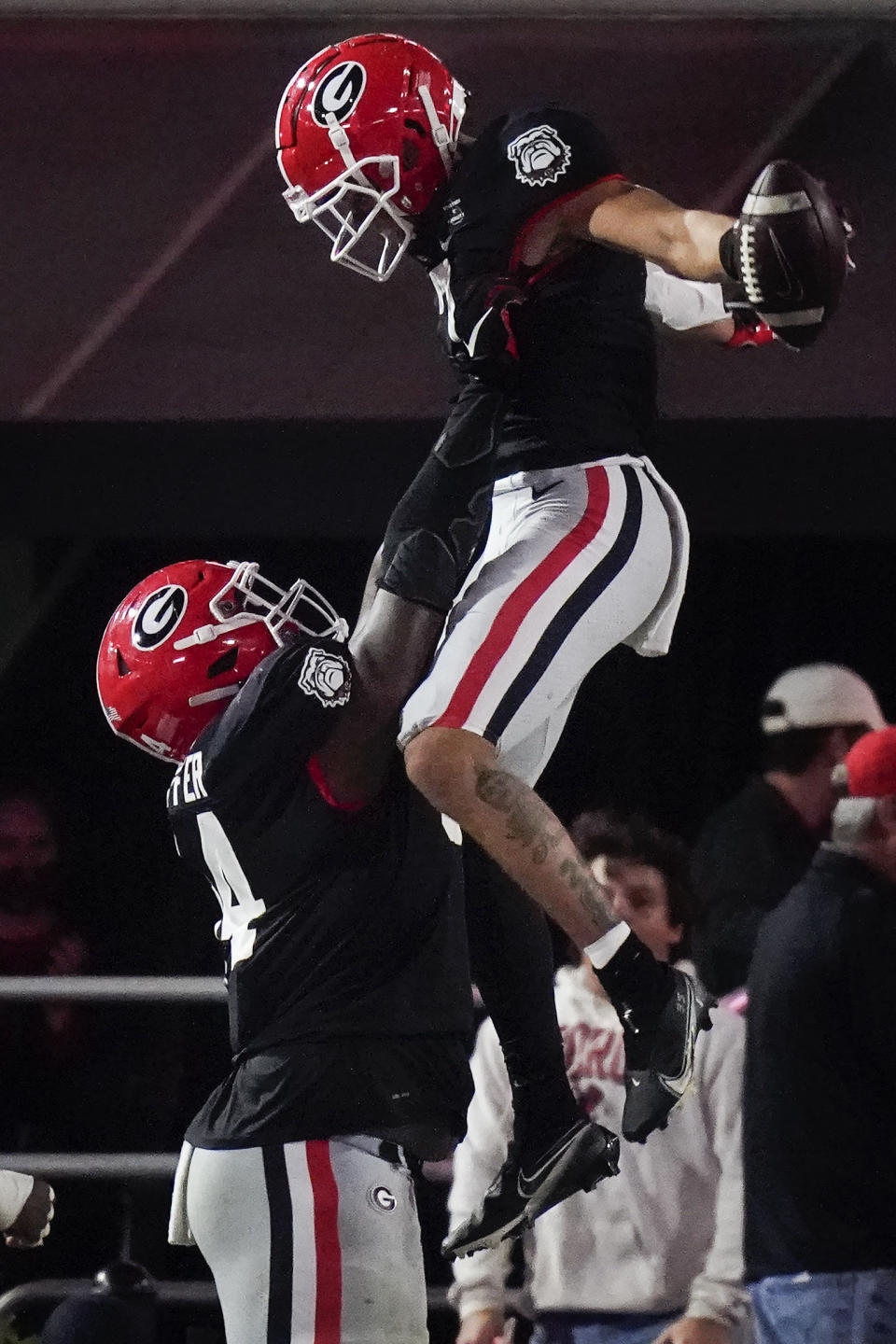 Georgia offensive lineman Justin Shaffer, left, picks up wide receiver Jermaine Burton to celebrate Burton's touchdown against Mississippi State during the first half of an NCAA college football game Saturday, Nov. 21, 2020, in Athens, Ga. (AP Photo/Brynn Anderson)