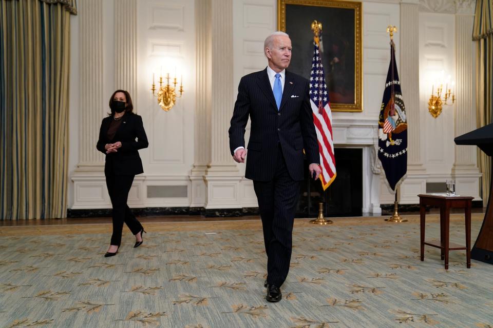 President Joe Biden holds a face mask after speaking about efforts to combat COVID-19, in the State Dining Room of the White House, Tuesday, March 2, 2021, in Washington. Vice President Kamala Harris is at left (AP)
