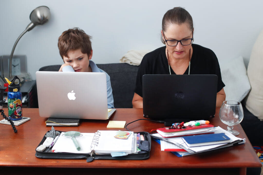 Phoenix Crawford does school work on a laptop while his mum Donna Eddy replies to client emails on April 09, 2020 in Sydney, Australia. (Photo by Brendon Thorne/Getty Images)