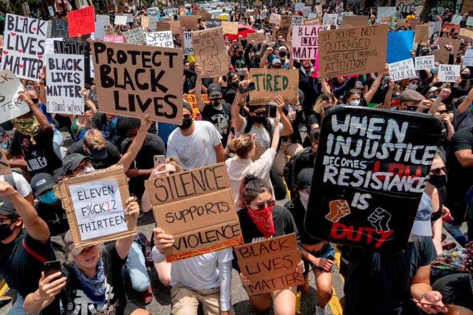 Protesters kneel in front of the police during a demonstration over the death of George Floyd in Los Angeles on 2 June 2020.