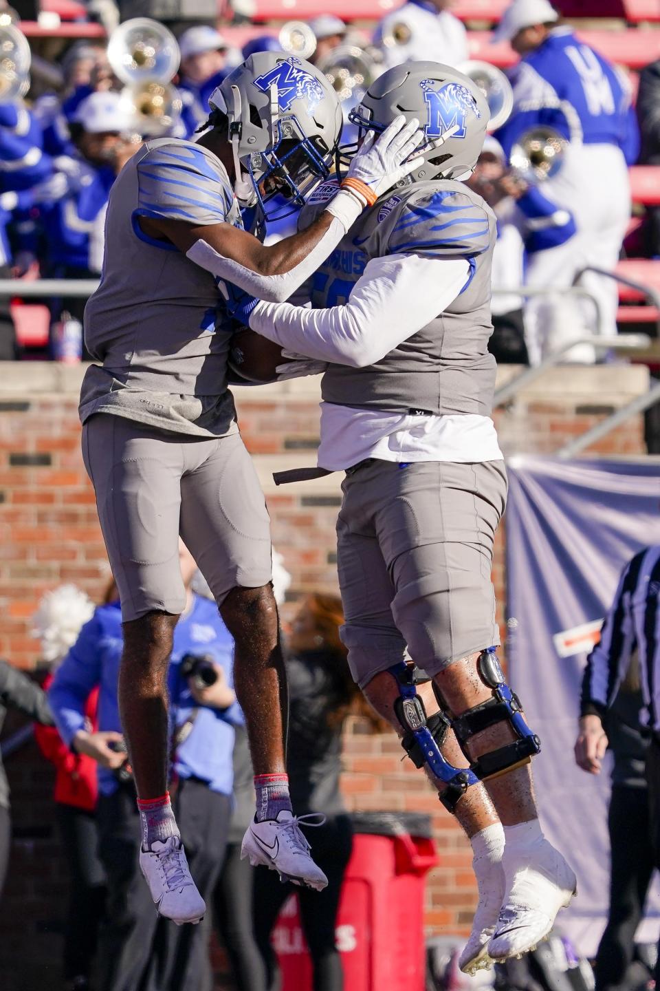 Memphis wide receiver Eddie Lewis (18) and offensive lineman Davion Carter (56) celebrate after Lewis scored a touchdown during the first half of the First Responders Bowl NCAA college football game against Utah State, Tuesday, Dec. 27, 2022, in Dallas. (AP Photo/Sam Hodde)