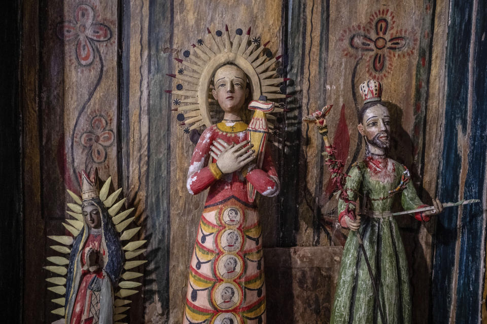 Restored bultos, or three-dimensional santos, are displayed inside St. Anthony's Catholic church, in Cordova, New Mexico, Friday, April 14, 2023. Threatened by depopulation, dwindling congregations and fading traditions, some faithful are fighting to save their historic adobe churches and the uniquely New Mexican way of life they represent. (AP Photo/Roberto E. Rosales)