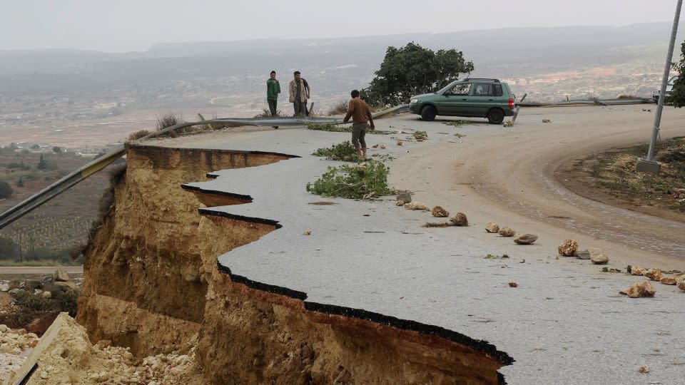 People stand in a damaged road as a powerful storm and heavy rainfall flooded hit Shahhat city, Libya, September 11, 2023.  - Omar Jarhman/Reuters