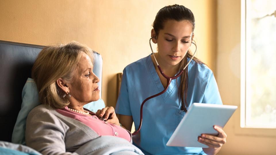 nurse examining a senior patient with a stethoscope