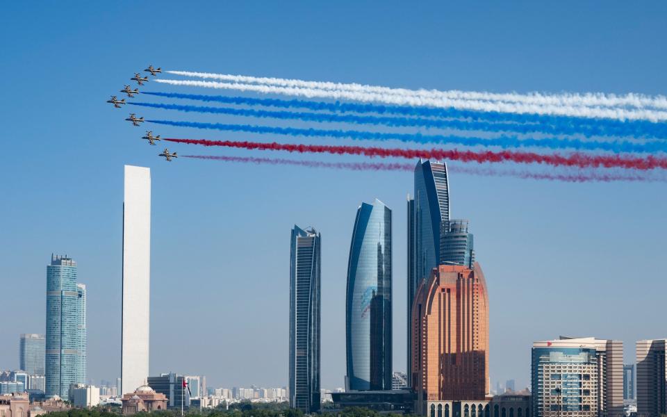 An aerobatic team performs a flypast as Vladimir Putin arrives for a state visit in Abu Dhabi