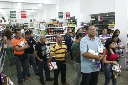 People line up to buy basic goods at a supermarket in San Cristobal January 14, 2015. REUTERS/Carlos Eduardo Ramirez