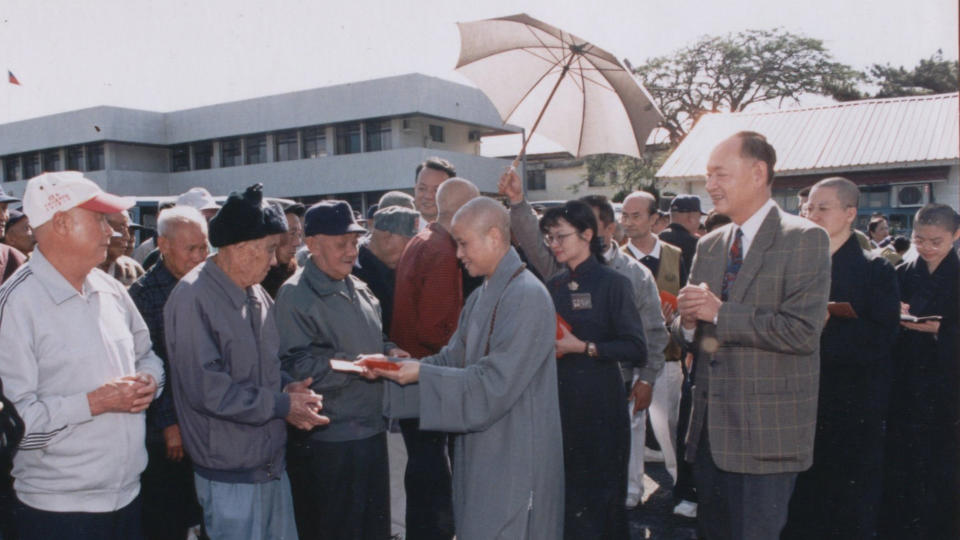 一九九七年大年初一，  證嚴上人由當時榮家主任呂興武陪同，帶領慈濟功德會志工與常住師父到榮家慰問榮民，並致贈每人福慧紅包。(花蓮榮家提供)