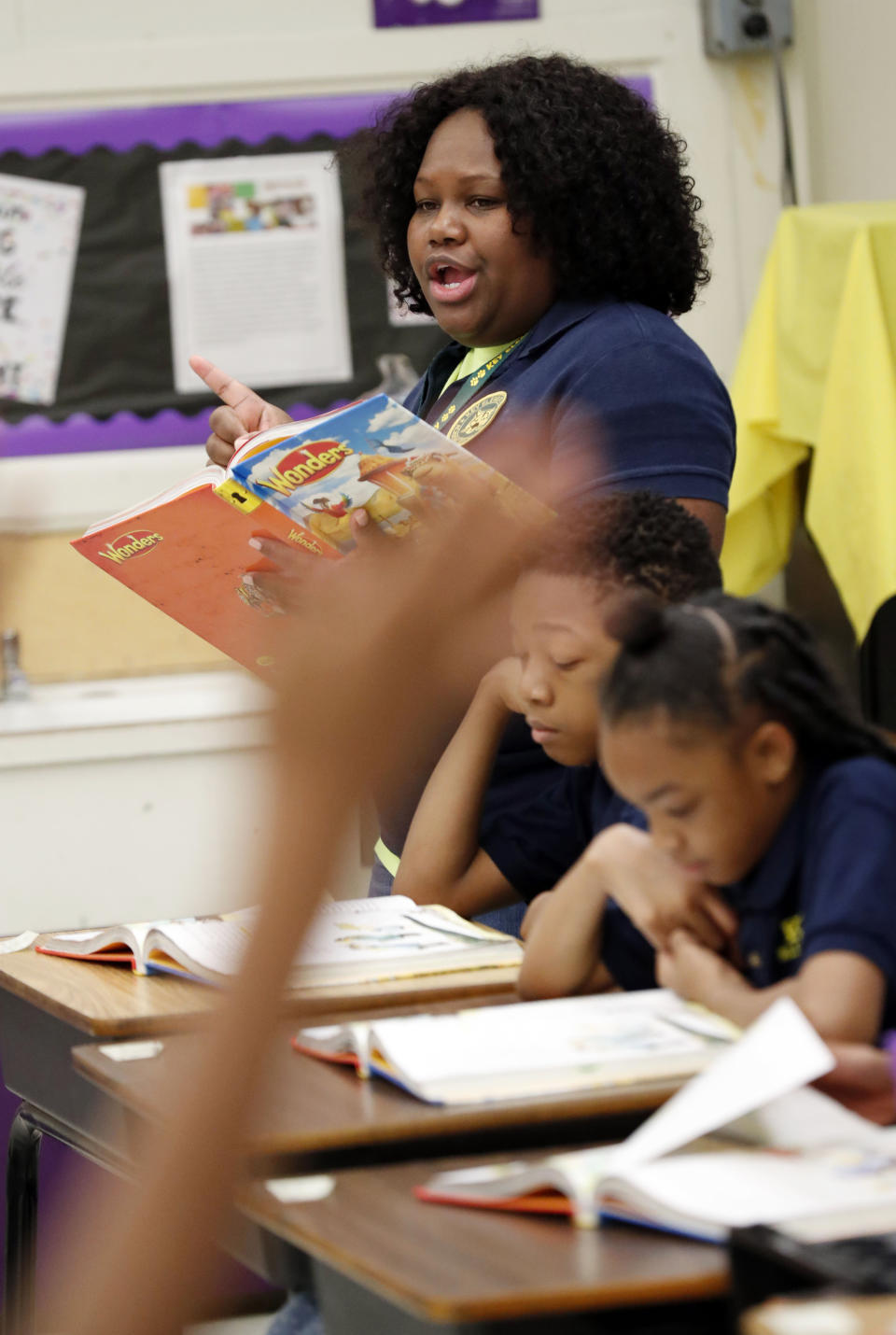 FILE - In this April 18, 2019 file photo, an anxious student raises her hand as Key Elementary School third grade teacher April Tate leads the class in a reading exercise, in Jackson, Miss. Nationally, lower-performing students are doing worse in math and reading, thus dragging down overall results on the Nation's Report Card. America's eighth graders are falling behind in math and reading, while fourth graders are doing slightly better in reading, according to the latest results from the Nation's Report Card. (AP Photo/Rogelio V. Solis, File)