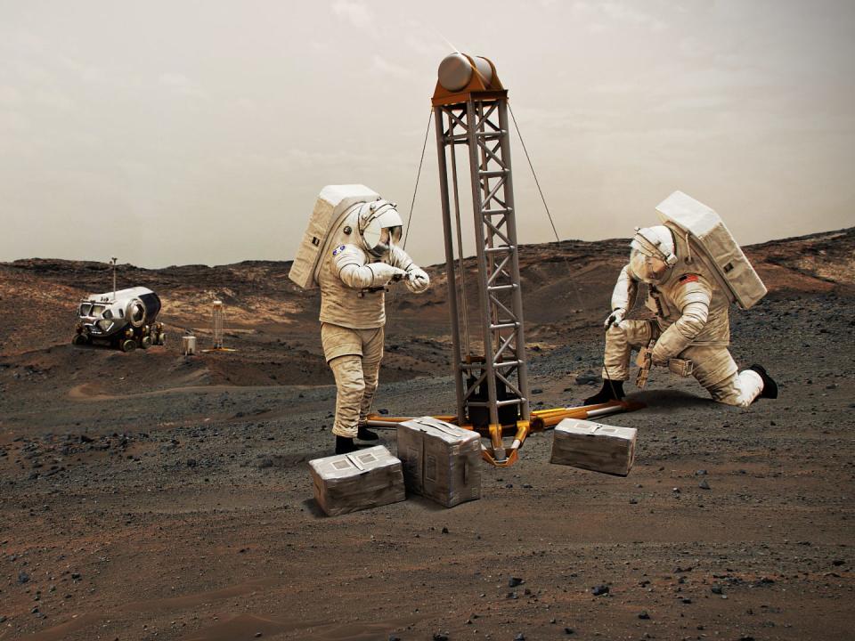 illustration shows astronauts using equipment on mars