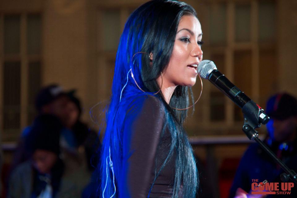 Jhene Aiko looks breath-taking in an all-black shiny outfit during a performance