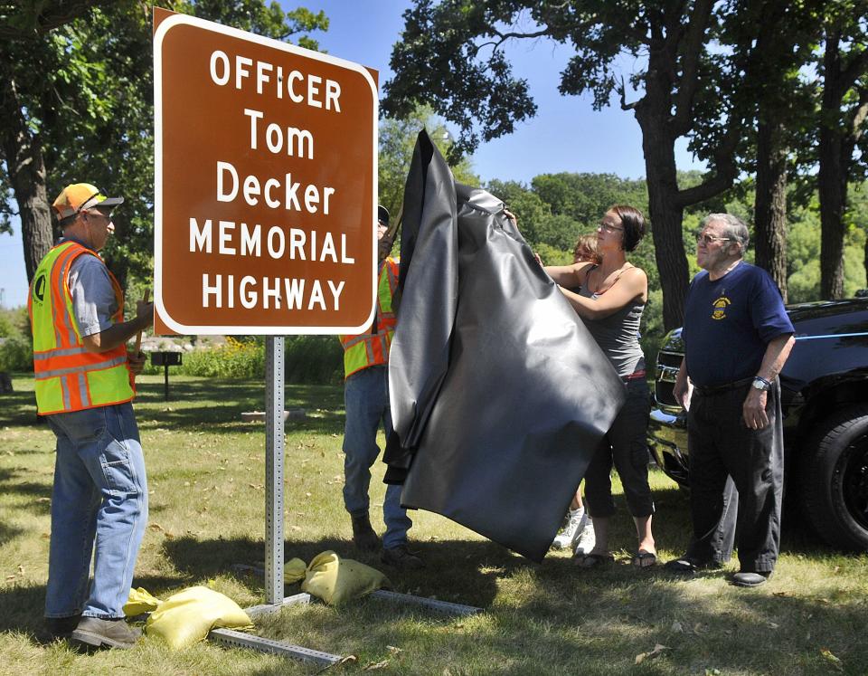 Officer Tom Decker's widow, Alicia, and parents, Rosella and John Decker unveil a new sign renaming the portion of Minnesota Highway 23 through Cold Spring and Richmond as Officer Tom Decker Memorial Highway during a ceremony Thursday, Aug. 22 in Cold Spring. Officer Tom Decker's widow, Alicia, and parents, Rosella and John Decker unveil a new sign renaming the portion of Minnesota Highway 23 through Cold Spring and Richmond as Officer Tom Decker Memorial Highway during a ceremony Thursday, Aug. 22, 2016 in Cold Spring.