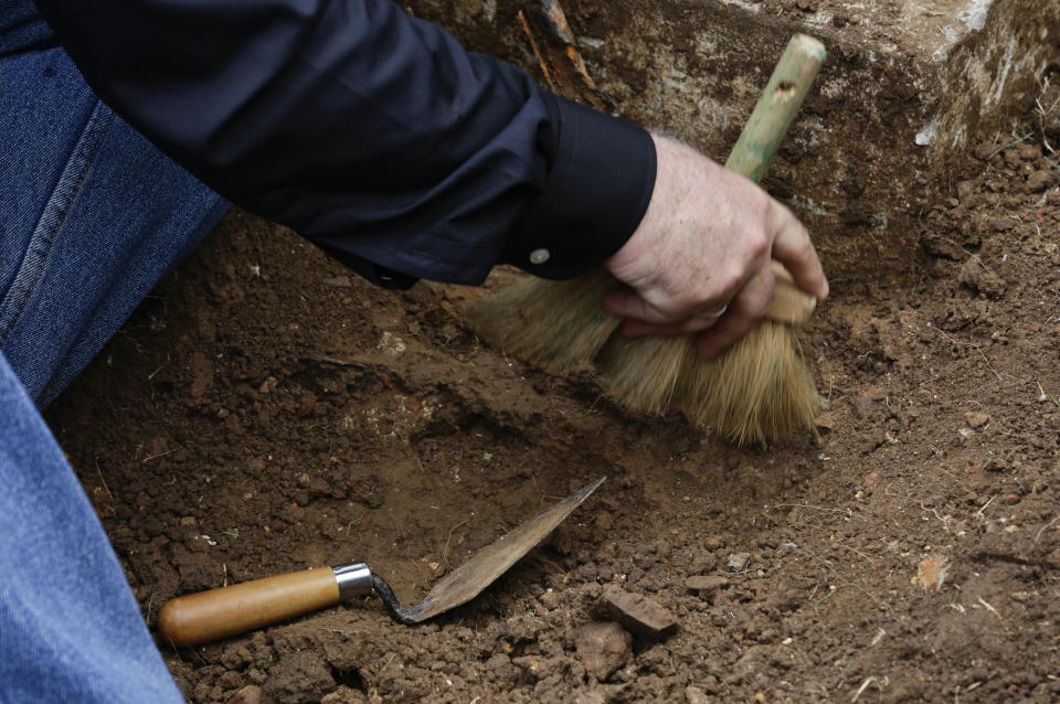 Maritime archaeologist James Delgado sweeps away debris on the gravesite of Julius H. Kroehl before exhuming his body from Amador Cemetery in the Chorrillo neighborhood of Panama City, Thursday, Oct. 11, 2018. The remains of Kroehl, a German-American who was a pioneer on the design of the first submarine to submerge successfully at depth, are being moved to Corozal Cemetery, a cemetery where American veterans are buried. (AP Photo/Arnulfo Franco)