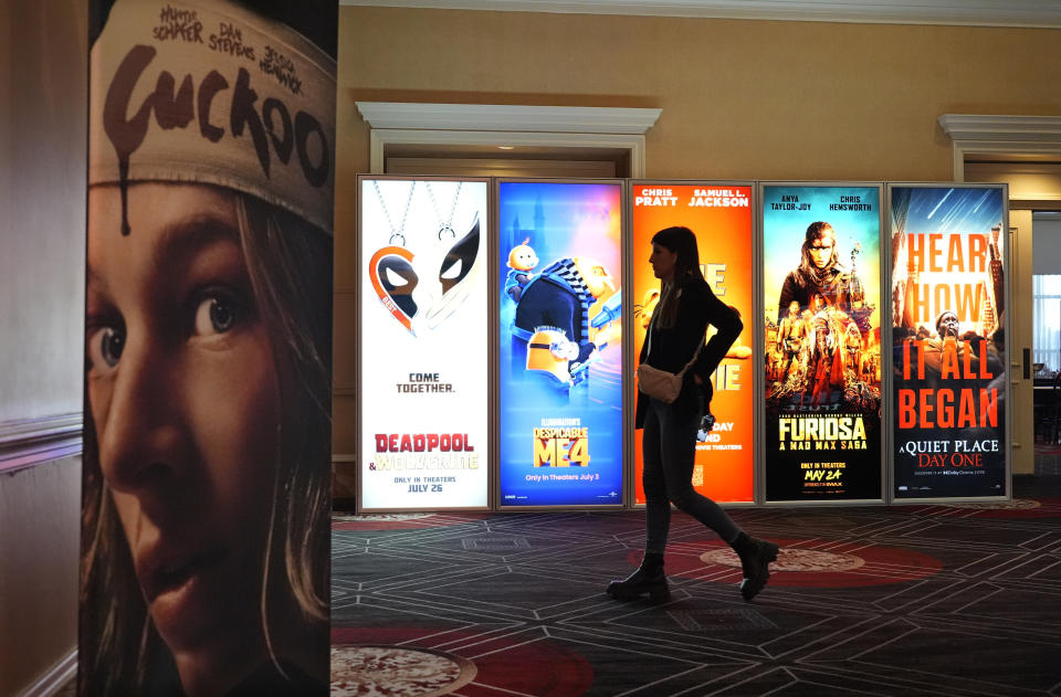 A visitor walks past advertisements for upcoming movies on the opening day of CinemaCon 2024 at Caesars Palace, Monday, April 8, 2024, in Las Vegas. The four-day convention of the National Association of Theatre Owners (NATO) runs through Thursday. (AP Photo/Chris Pizzello)