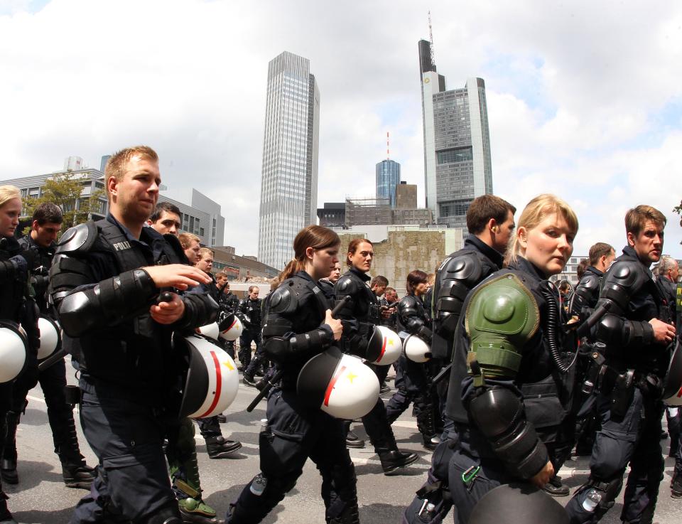 German police officers escort an anti capitalism protest march with some 20,000 people in Frankfurt, Germany, Saturday, May 19, 2012. Protesters peacefully filled the city center of continental Europe's biggest financial hub in their protest against the dominance of banks and what they perceive to be untamed capitalism, Frankfurt police spokesman Ruediger Regis said.  The protest group calling itself Blockupy has called for blocking the access to the European Central Bank, which is located in Frankfurt's business district.  (AP Photo/Michael Probst)