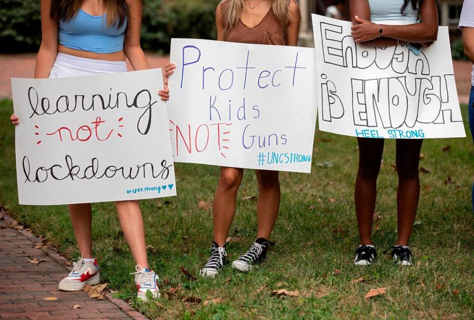 People hold signs during a student-led rally at UNC-Chapel Hill in support of gun control on Wednesday, Aug. 30, 2023. A graduate student has been charged with first-degree murder following a Monday shooting that left a faculty member dead on the campus.