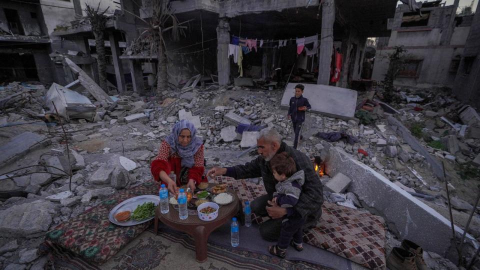 PHOTO: The Palestinian Al-Naji family eats an iftar meal, the breaking of fast, amidst the ruins of their family house, on the first day of the Muslim holy fasting month of Ramadan, in Deir el-Balah in the central Gaza Strip, Mar. 11, 2024. (AFP via Getty Images)