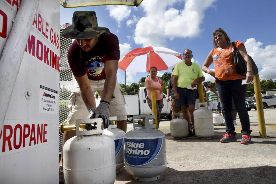 <p>Gustavo Galindo, left, fills propane tanks at an Exxon gas station in Davie, Fla., Thursday, Sept. 7, 2017, as a long line of people wait in line as residents prepare for Hurricane Irma. (Photo: Taimy Alvarez/South Florida Sun-Sentinel via AP) </p>