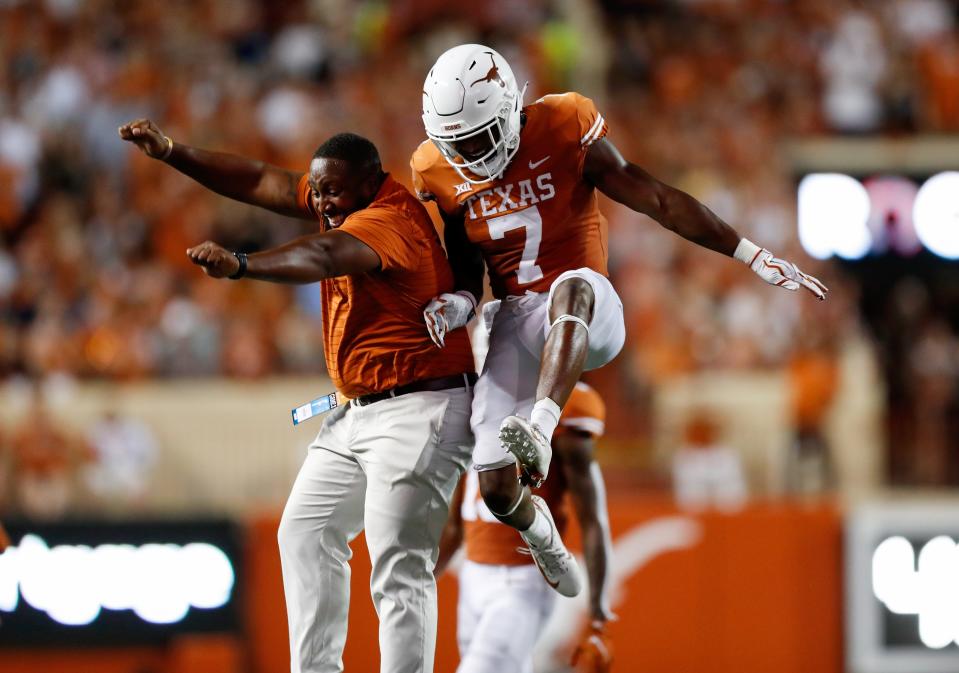 AUSTIN, TEXAS - SEPTEMBER 18: Keilan Robinson #7 of the Texas Longhorns is congratulated by a member of the coaching staff after blocking a punt in the first half against the Rice Owls at Darrell K Royal-Texas Memorial Stadium on September 18, 2021 in Austin, Texas. (Photo by Tim Warner/Getty Images)