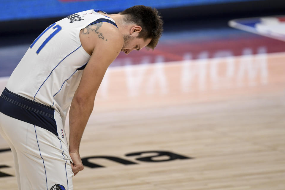 Luka Doncic puts his hands on his knees and looks down during a game.