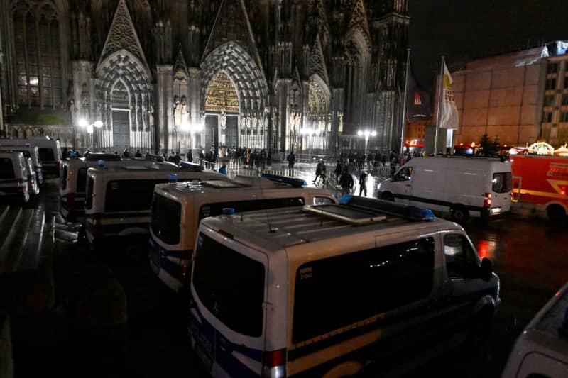 Police officers order the admission of worshippers to Cologne Cathedral. Due to indications of a planned Islamist attack, the police have stepped up security measures. Roberto Pfeil/dpa
