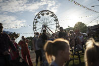 People watch a pig race at the Mississippi State Fair, Wednesday, Oct. 7, 2020, in Jackson, Miss. At the fair, which is held every year in October and attracts people from across the racial spectrum, the vast majority of Black people are wearing masks. Most white people do not. (AP Photo/Wong Maye-E)