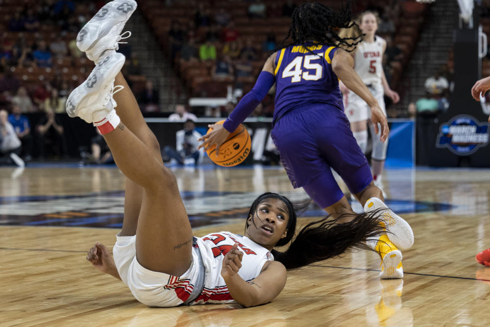 Utah's Dasia Young falls tio the floor as LSU's Alexis Morris (45) dribbles the ball in the background during the second half of a Sweet 16 college basketball game of the women's NCAA Tournament in Greenville, S.C., Friday, March 24, 2023. (AP Photo/Mic Smith)