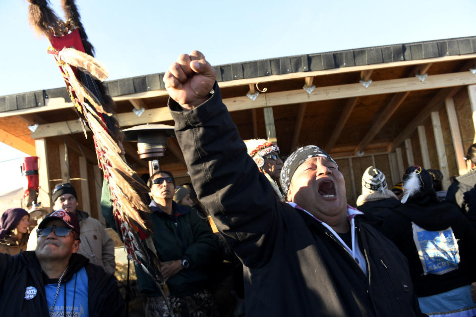Troy Fairbanks, right, of the Standing Rock Sioux tribe cheers after hearing Chief Arvol Looking Horse announce to members of over 300 nations that the&nbsp;pipeline's construction has been halted.