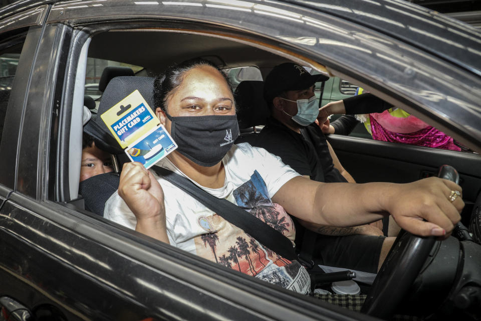 Wairere Castle shows her gift card after receiving her vaccination in Rotorua, New Zealand, Saturday, Oct. 16, 2021. New Zealand health care workers have administered a record number of vaccine jabs as the nation holds a festival aimed at getting more people inoculated against the coronavirus. (Andrew Warner/NZME via AP)