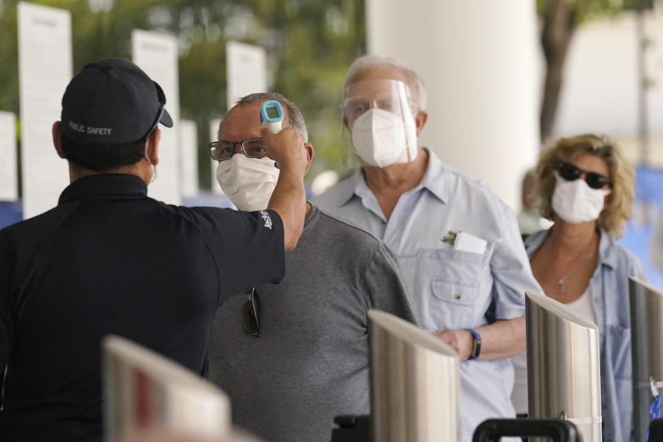 FILE - In this Feb. 8, 2021, file photo, Florida seniors have their temperatures taken before receiving the second dose of the Pfizer COVID-19 vaccine at Jackson Health System in Miami. COVID-19 hospitalizations are plunging among older Americans. The falling numbers show the country’s vaccination strategy is working, pushing deaths lower and easing pressure on the frayed hospital system. (AP Photo/Marta Lavandier, File)