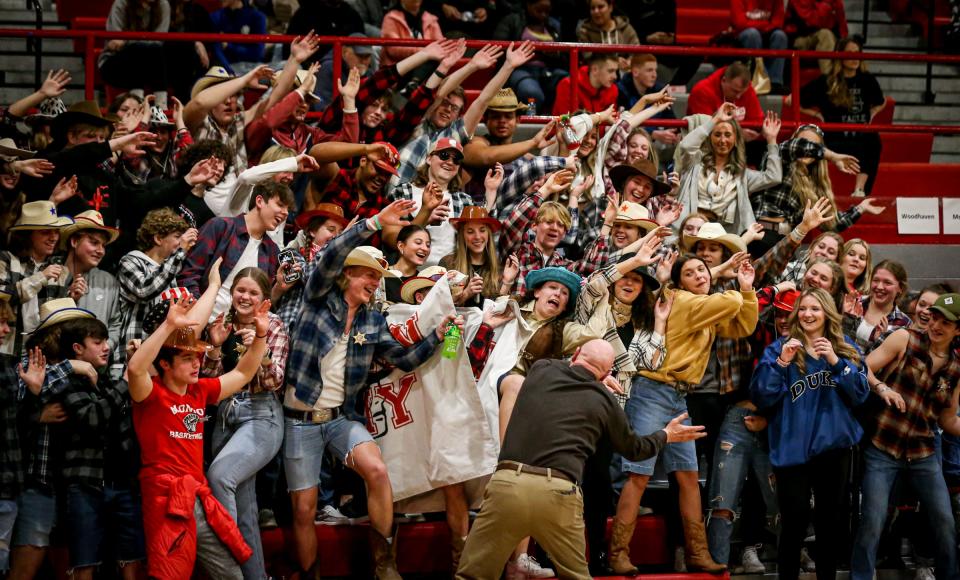 Monroe athletic director John Ray leads the Trojan student section in a cheer during a district game in 2022.