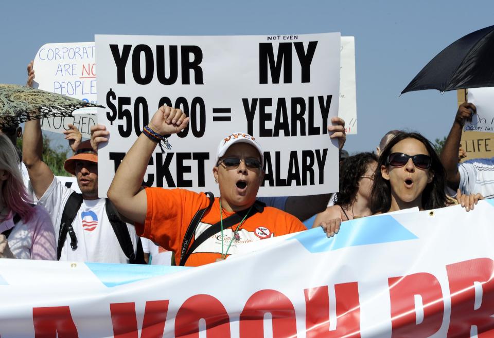 Maria d. Maisonet, from New York's Brooklyn borough, center, marches with protestors from MoveOn.org, the Occupy Movement and the Long Island Progressive at a fundraiser for Republican presidential candidate Mitt Romney on Sunday, July 8, 2012, in Southampton, N.Y. Romney's fundraiser at the Southampton estate of billionaire industrialist David Koch asked donors to give $50,000 per person or $75,000 per couple. (AP Photo/Kathy Kmonicek)