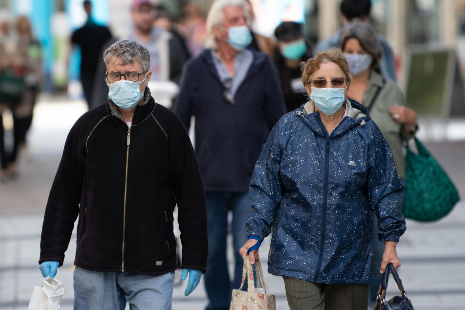 CARDIFF, WALES - SEPTEMBER 23: A man and woman wear surgical face masks on Queen Street on September 23, 2020 in Cardiff, Wales. Four more counties in south Wales went into local lockdown this week, leaving more than a quarter of the Welsh population under tighter restrictions. Merthyr Tydfil, Bridgend, Blaenau Gwent and Newport now have the same restrictions as Rhondda Cynon Taf and Caerphilly where people cannot leave except for a limited number of exemptions. Additionally,  pubs and bars will need to shut before 10pm.  (Photo by Matthew Horwood/Getty Images)