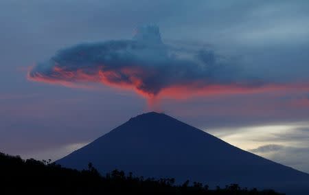 A plume of smoke above Mount Agung volcano is illuminated at sunset as seen from Amed, Karangasem Regency, Bali, Indonesia, November 30. REUTERS/Darren Whiteside/Files