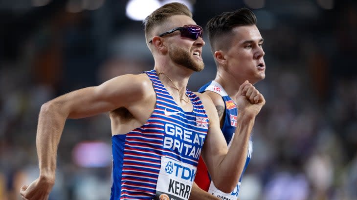 two men sprinting side by side in a final track event