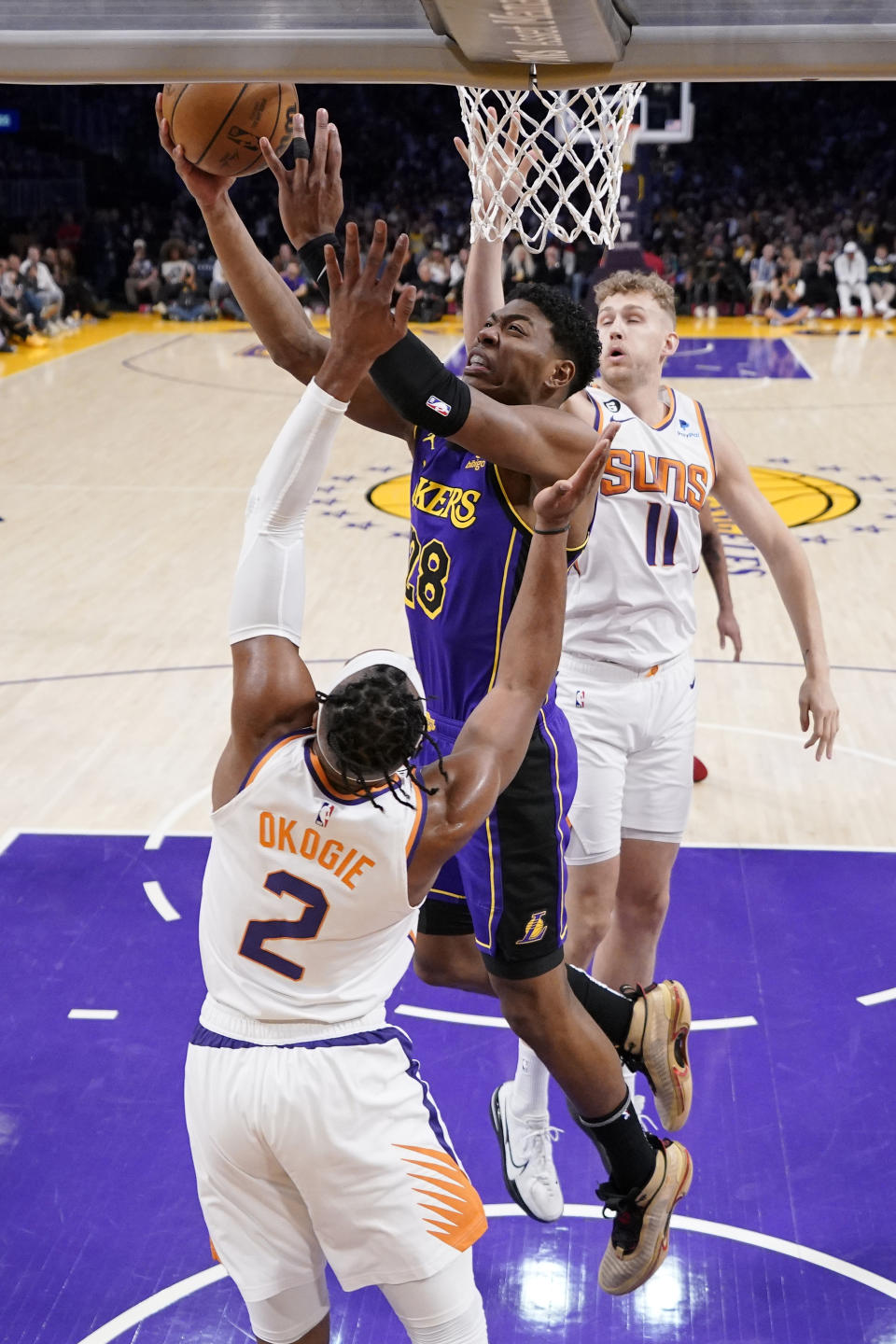 Los Angeles Lakers forward Rui Hachimura, center, shoots as Phoenix Suns forward Josh Okogie, left, and center Jock Landale defend during the first half of an NBA basketball game Friday, April 7, 2023, in Los Angeles. (AP Photo/Mark J. Terrill)