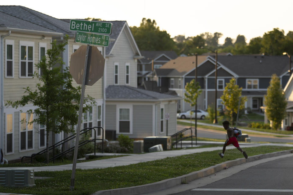 A child runs across the street in the Five Points neighborhood Friday, Aug. 4, 2023 in Knoxville, Tenn. The city saw a spike in gun deaths in 2020 and 2021, with a gun homicide rate that at one point in 2021 rivaled Chicago's. (AP Photo/George Walker IV)