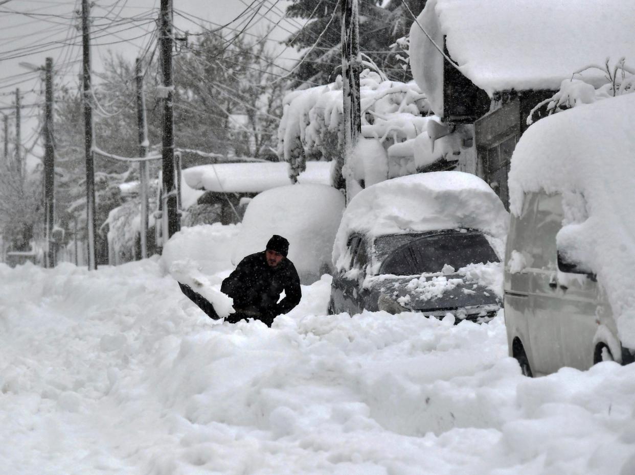 A man shovels snow, as he tries to clear his car in town of Isperih, Northeast Bulgaria (AP)